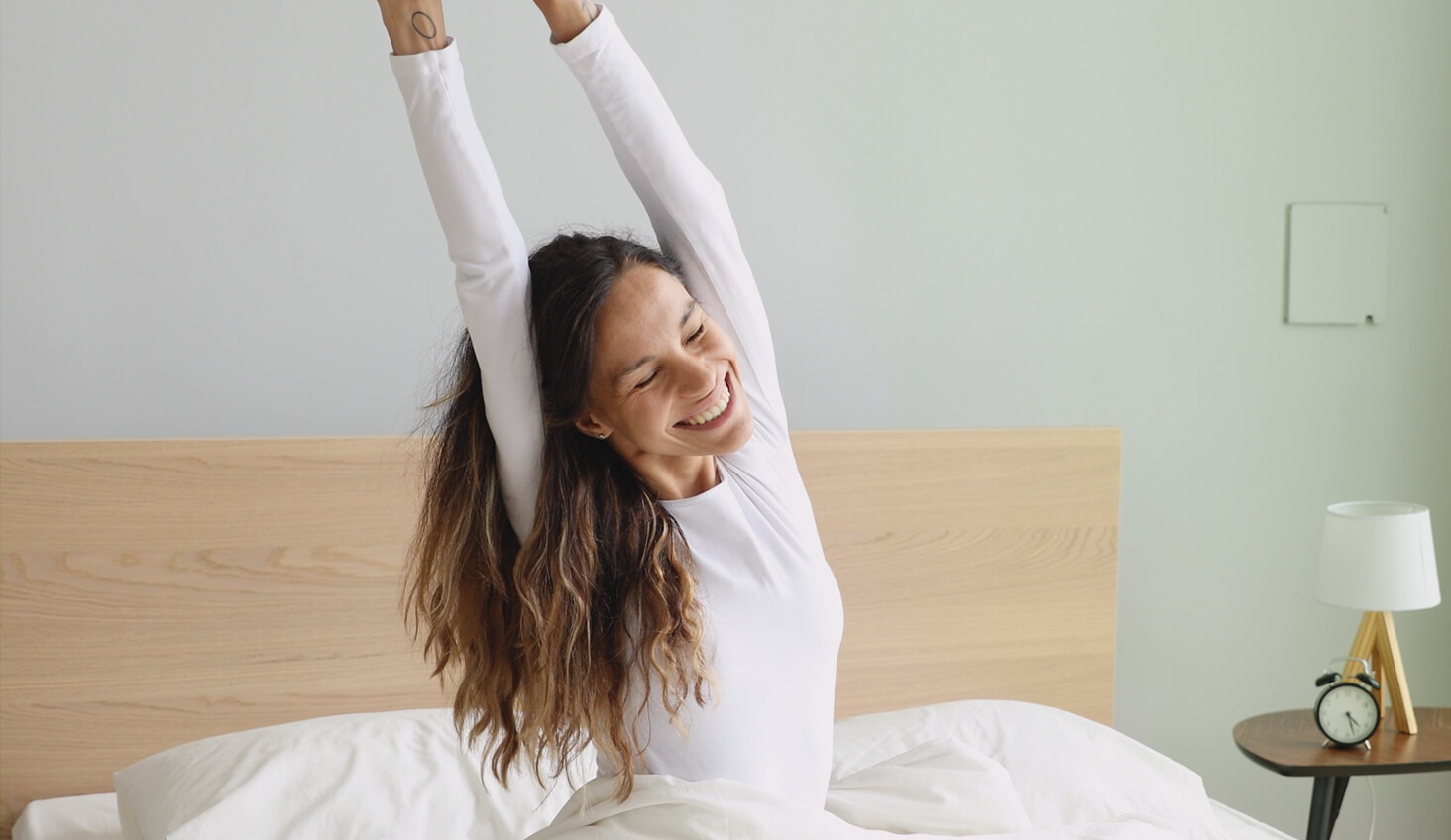 Mujer despertando cómoda en su cama