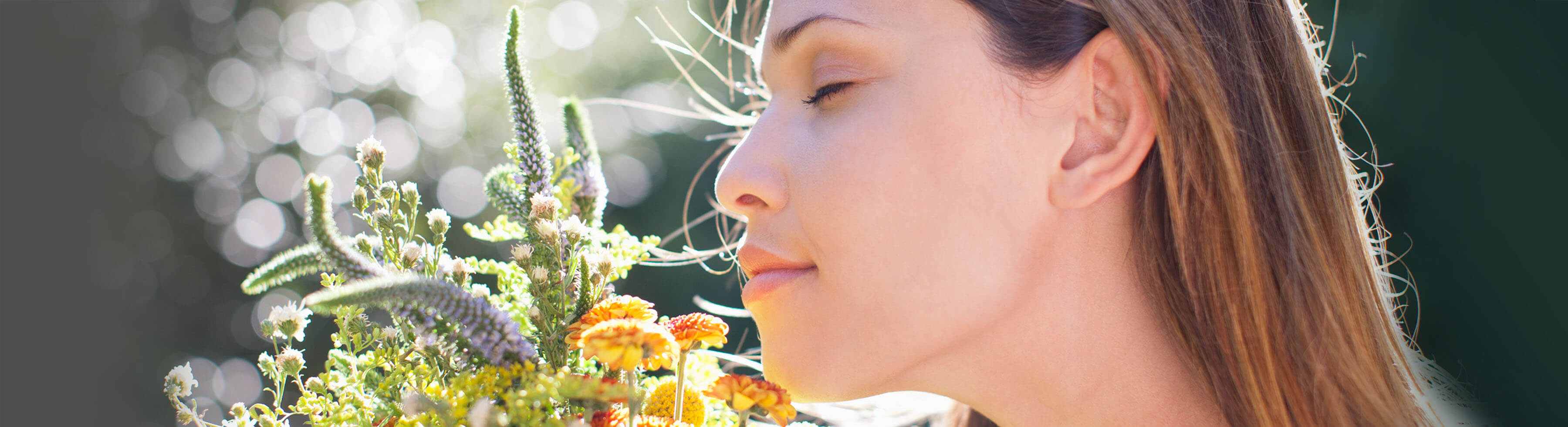 Mujer oliendo flores