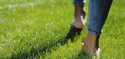 Pies descalzos caminando sobre un campo verde